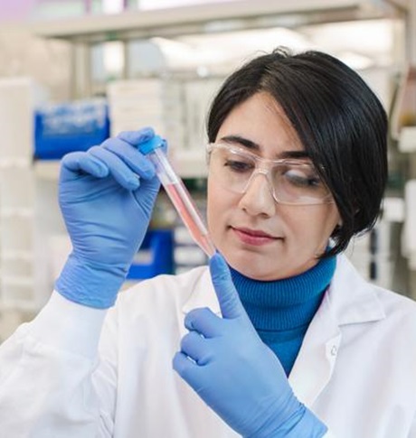 Wetenschapper kijkt naar een rij spuiten.